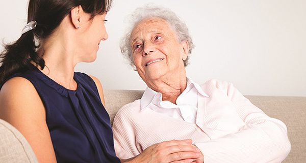senior woman holding hand with younger woman