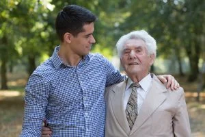 young marn with arm around senior man, Alzheimer's