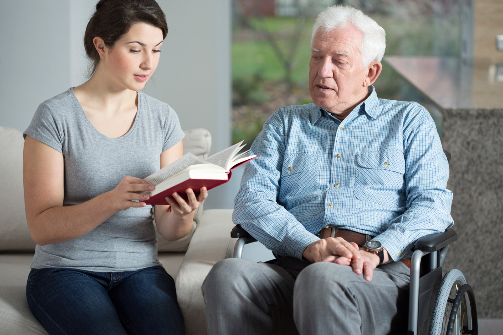 caregiver reading to senior living at home