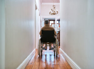senior disabled man in wheelchair in hallway