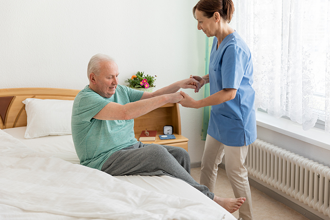 Female caregiver helping senior man