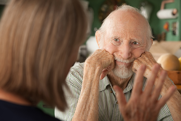 lady talking to senior man who is listening intently