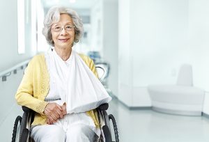 senior lady in wheelchair with arm in sling